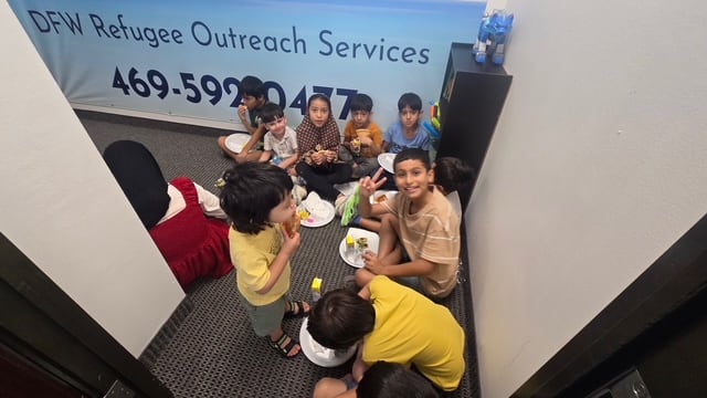 Refugee children sharing a meal together at the DFWROS community center