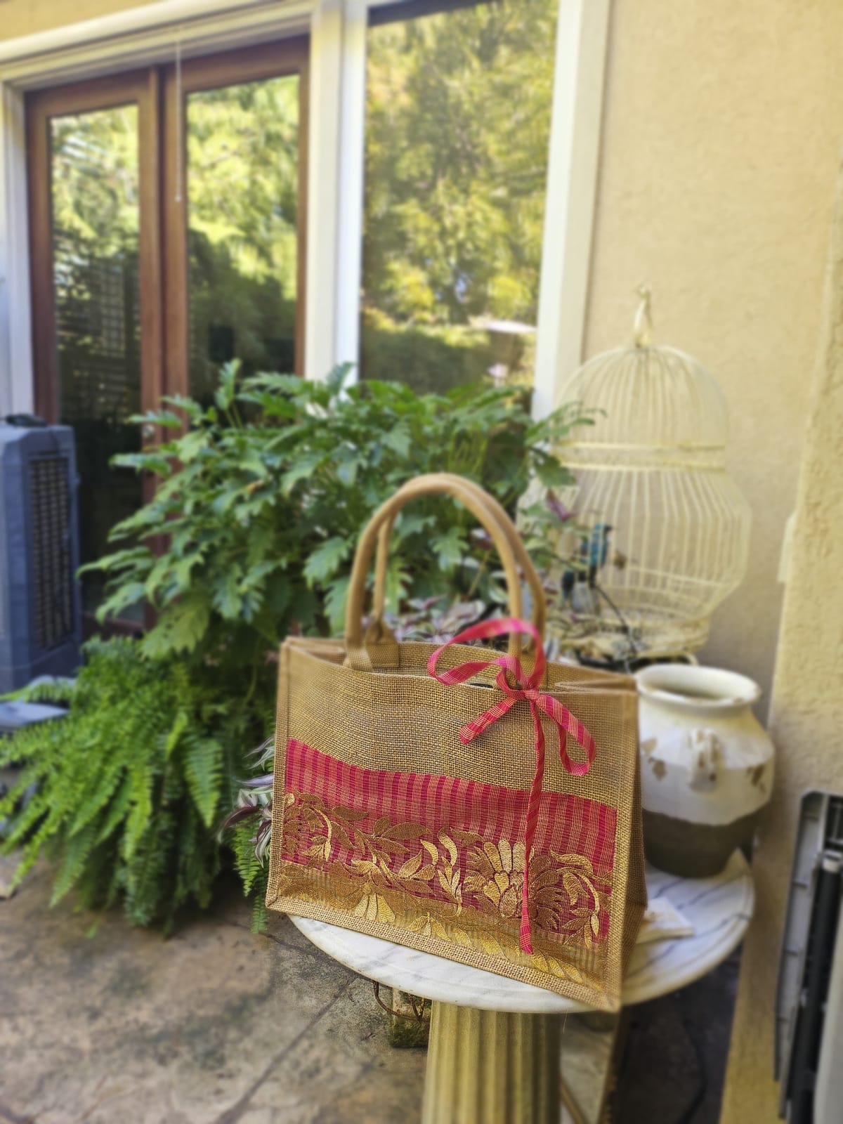 A burlap tote with gold hand-embroidery, made by the Hope Boutique artisans