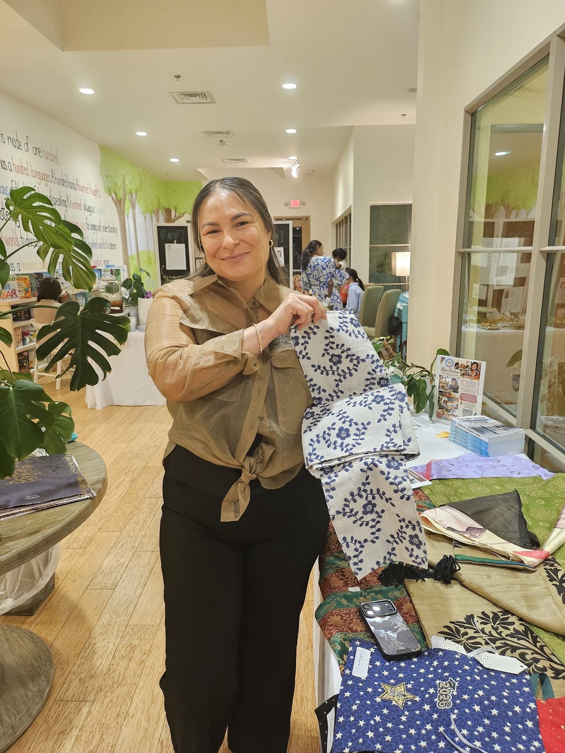 An embroidered table runner held up at a Hope Boutique pop-up